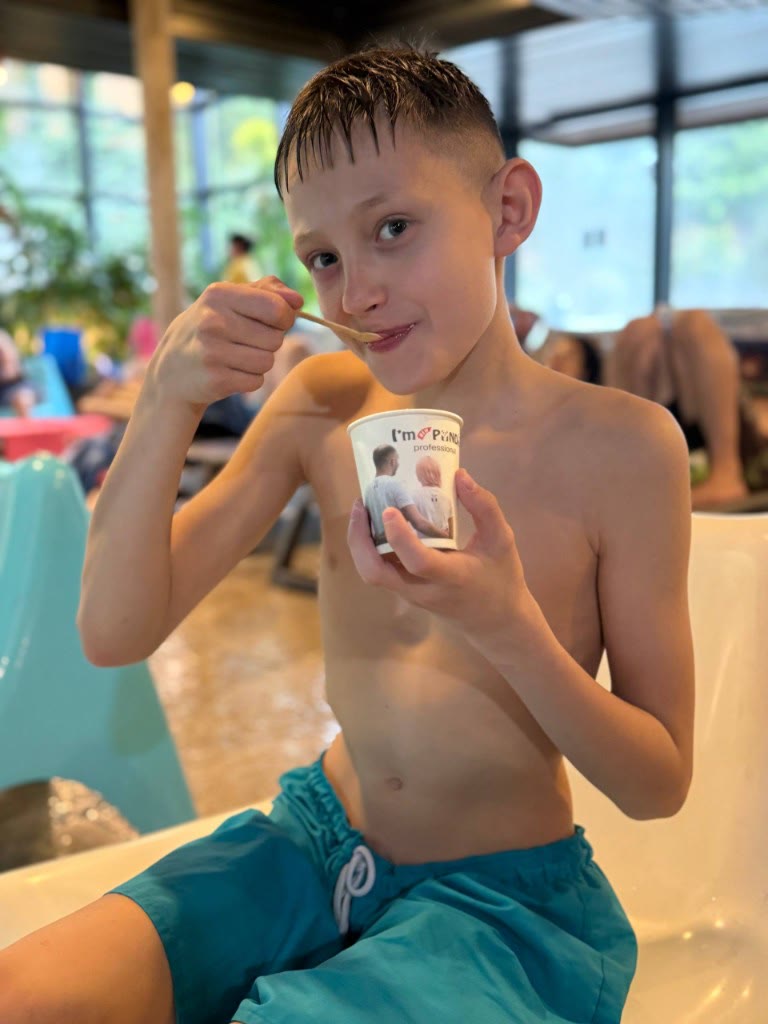 Junge geniesst Dessert im Panda-Becher